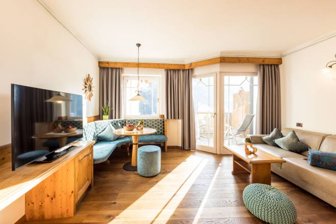 Doppelzimmer mit Couch und Balkon im Hotel Sonnenalm