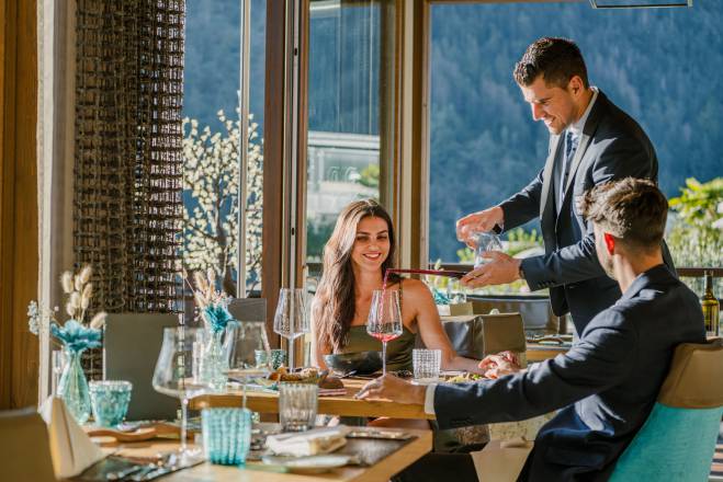 Paar bekommt beim Abendessen Wein eingeschenkt