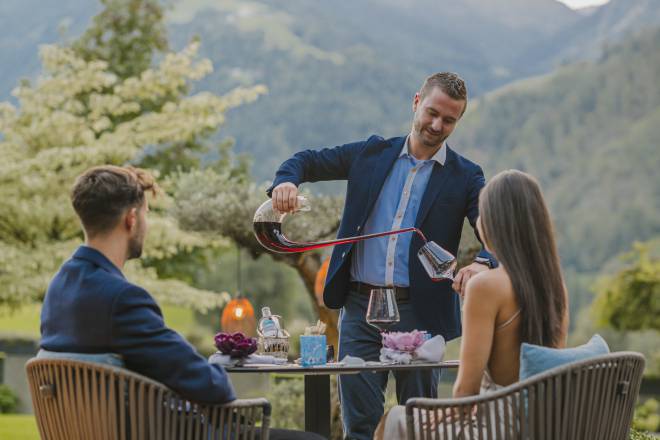 Juniorchef schenkt Paar Rotwein ein