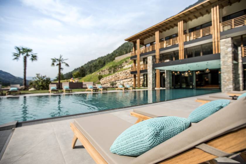 Sonnenliege am Pool mit Blick auf das Hotel Sonnenalm