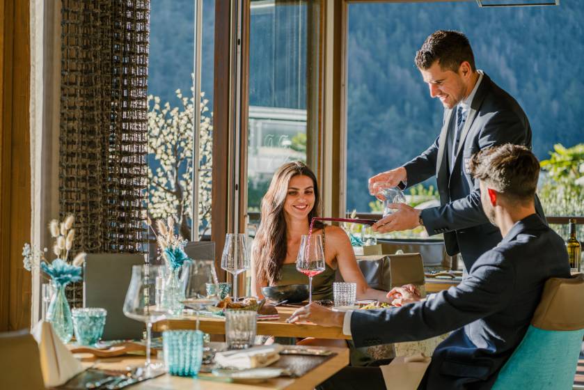 Paar bekommt beim Abendessen Wein eingeschenkt