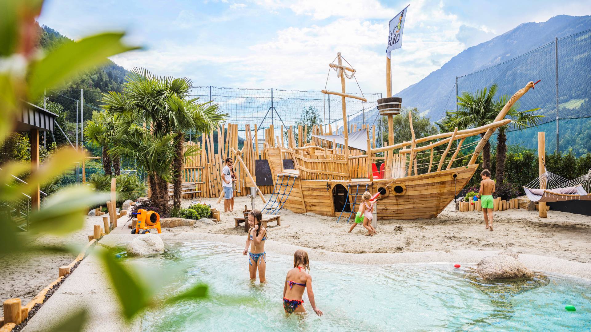 Kinder spielen am Holzschiff im Wasser