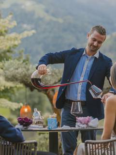 Juniorchef schenkt Paar Rotwein ein