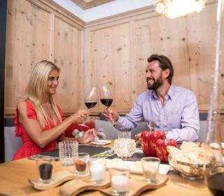 Paar beim Abendessen stößt mit Rotwein an