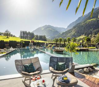 Schaukelstühle mit Blick auf die Alpen am Pool