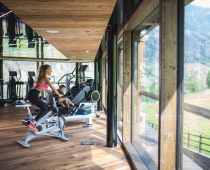 Frau sitzt auf Rennrad im Fitnessstudio