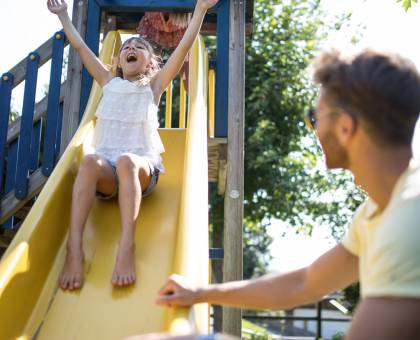 Eltern mit Kind an Rutsche