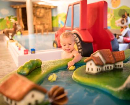 Kind spielt im Kinderpool Bereich