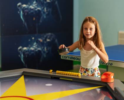 Kind spielt im Jugendraum Airhockey