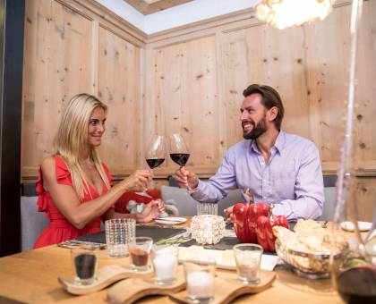 Paar beim Abendessen stößt mit Rotwein an