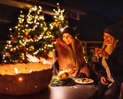 Frauen trinken Punsch am Feuer im Winter