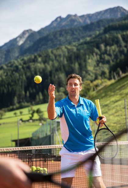 Mann wirft Tennisball