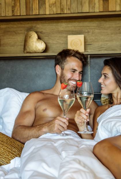 Paar trinkt Sekt im Bett