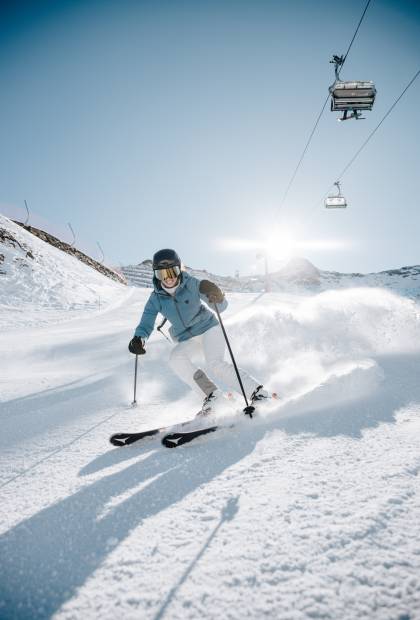 Skifahrerin bei Abfahrt im Schnee