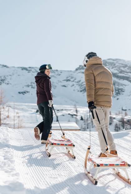 Paar zieht Schlitten im Schnee