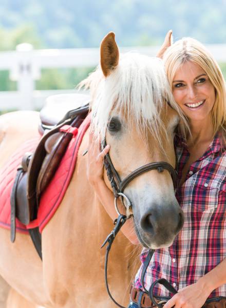 Frau posiert mit einem Pferd