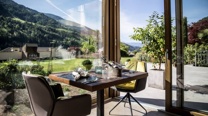 gedeckter Tisch im Restaurant mit Panoramablick auf die Alpen