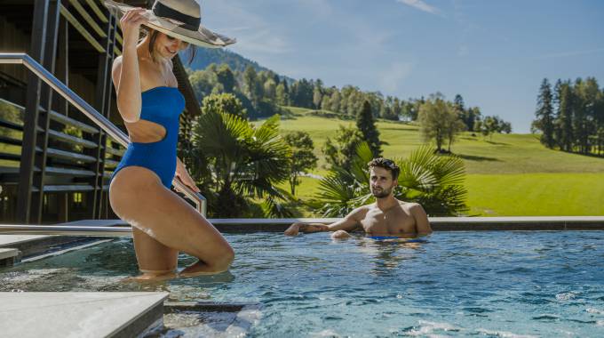Paar im Pool mit Blick auf die Südtiroler Alpen