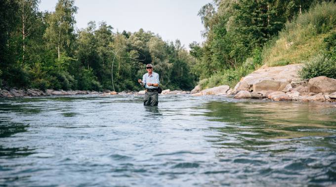 Angler steht im Wasser beim Fischen