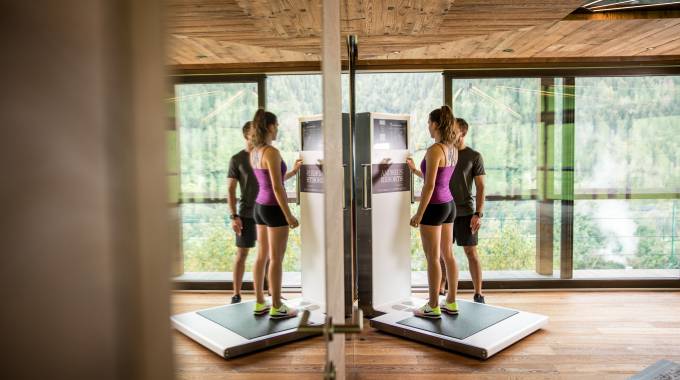 Frau steht auf Waage im Fitnessstudio