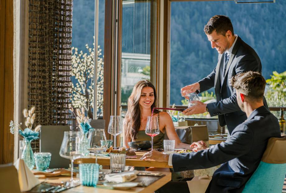 Paar bekommt beim Abendessen Wein eingeschenkt