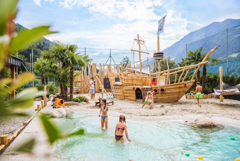 Kinder spielen am Holzschiff im Wasser