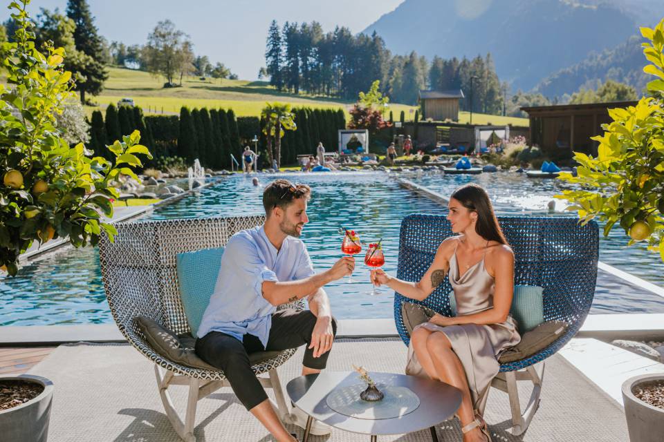 Paar stößt mit Aperitif am Pool an