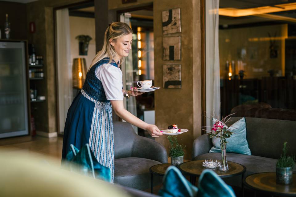Kellnerin serviert Kaffee und Kuchen